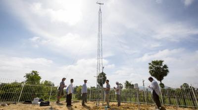 A group of people standing around a water tower.